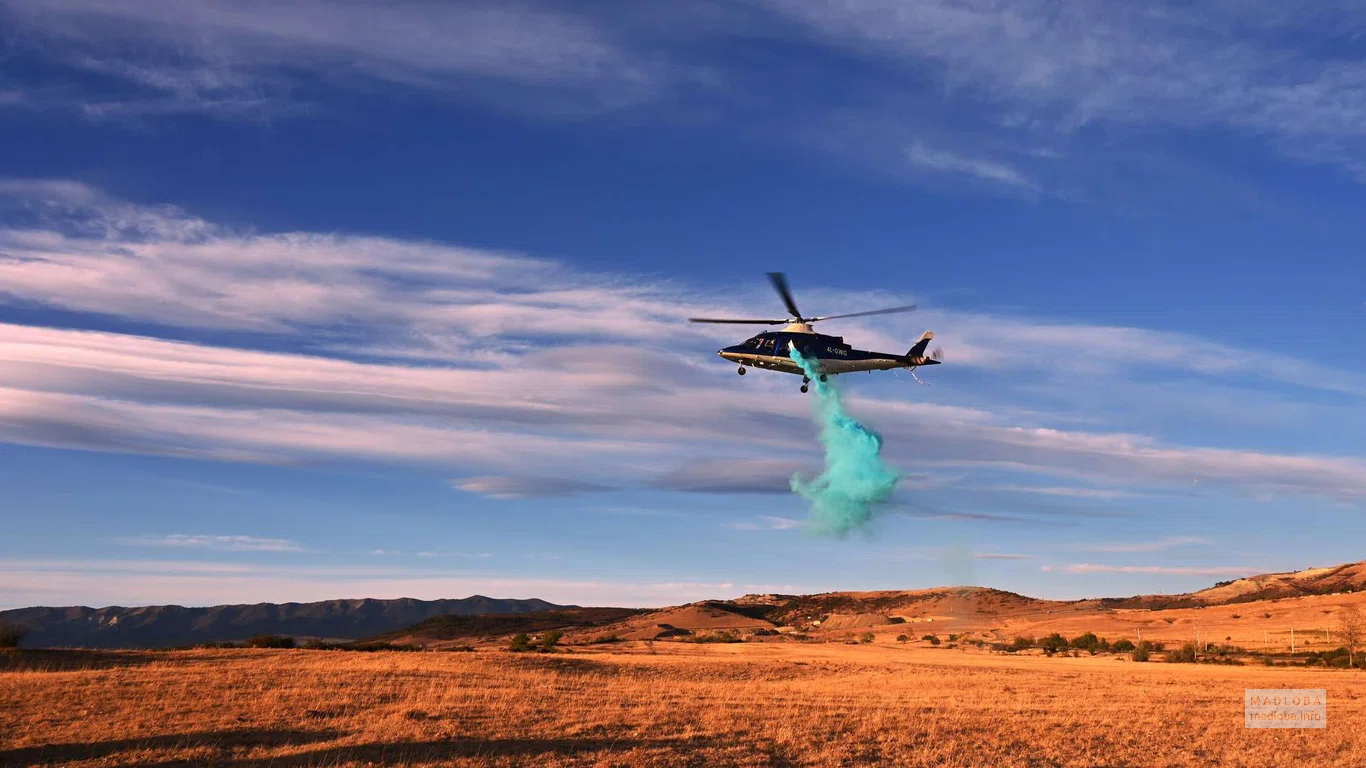 Вертолёт авиакомпании "Air Geo Sky" раскидывает дымовую шашку