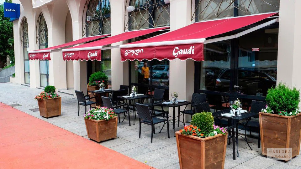 Летние столики под красными зонтиками ресторана Гауди