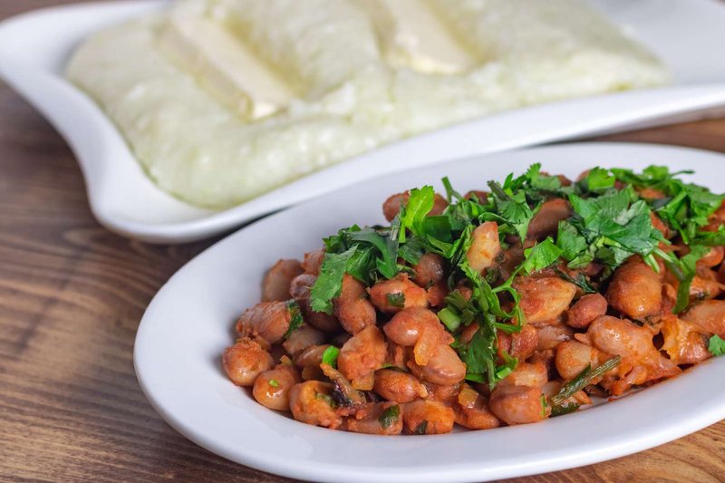 Порция фасоли с хмели-сунели и пури на фоне гор