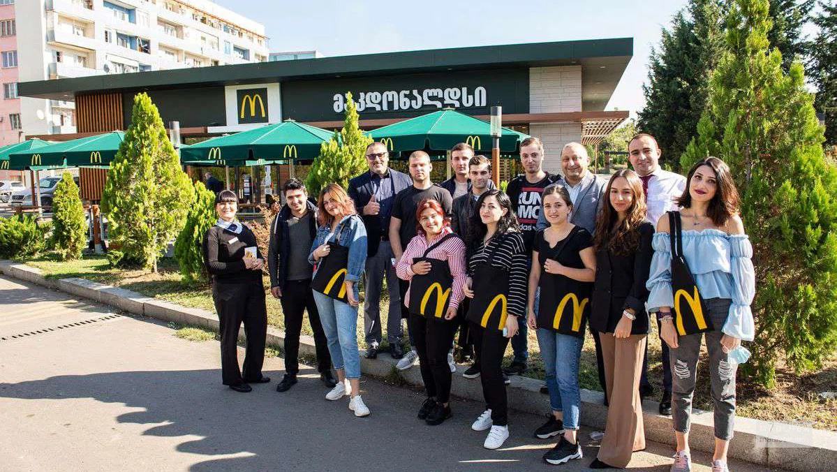 Сотрудники на фоне  "T&K Restaurants McDonald’s"