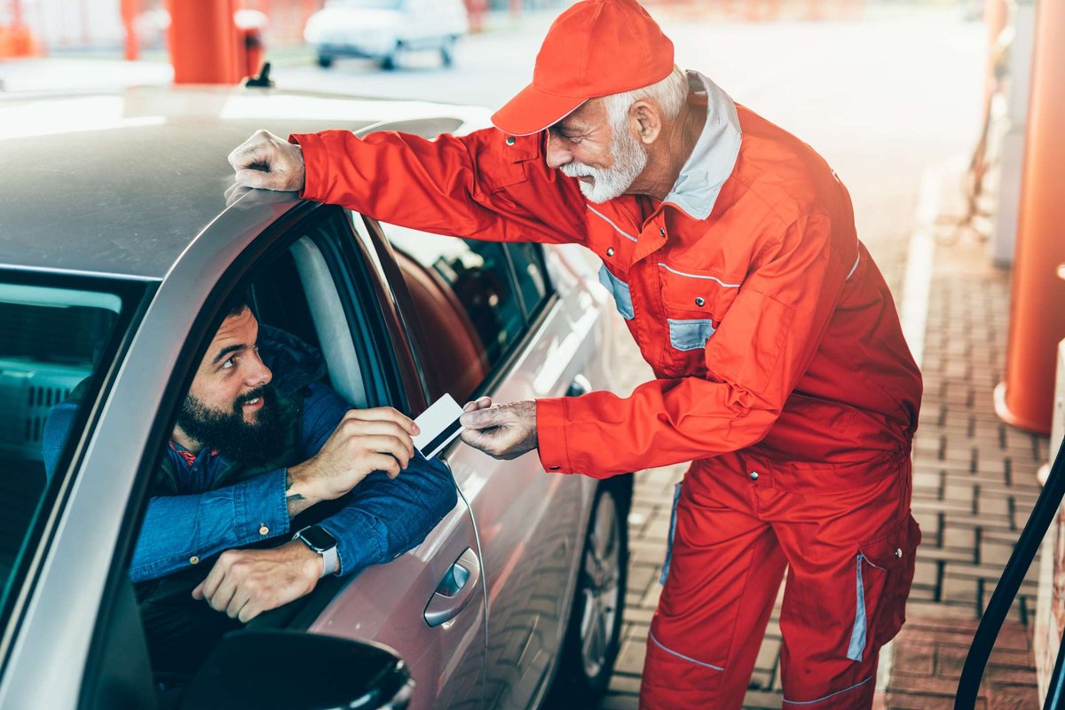 A man pays with a credit card at a gas station