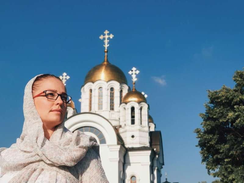 A woman against the backdrop of an Orthodox church