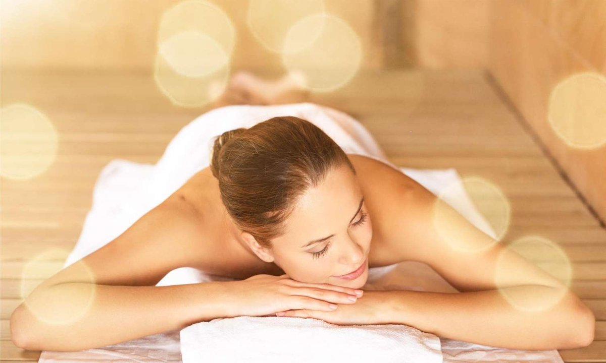 A young woman lies on her stomach in a salon after a relaxing massage.