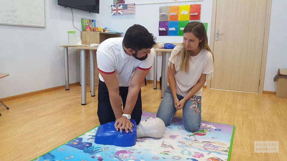 Врач учит делать массаж для сердца