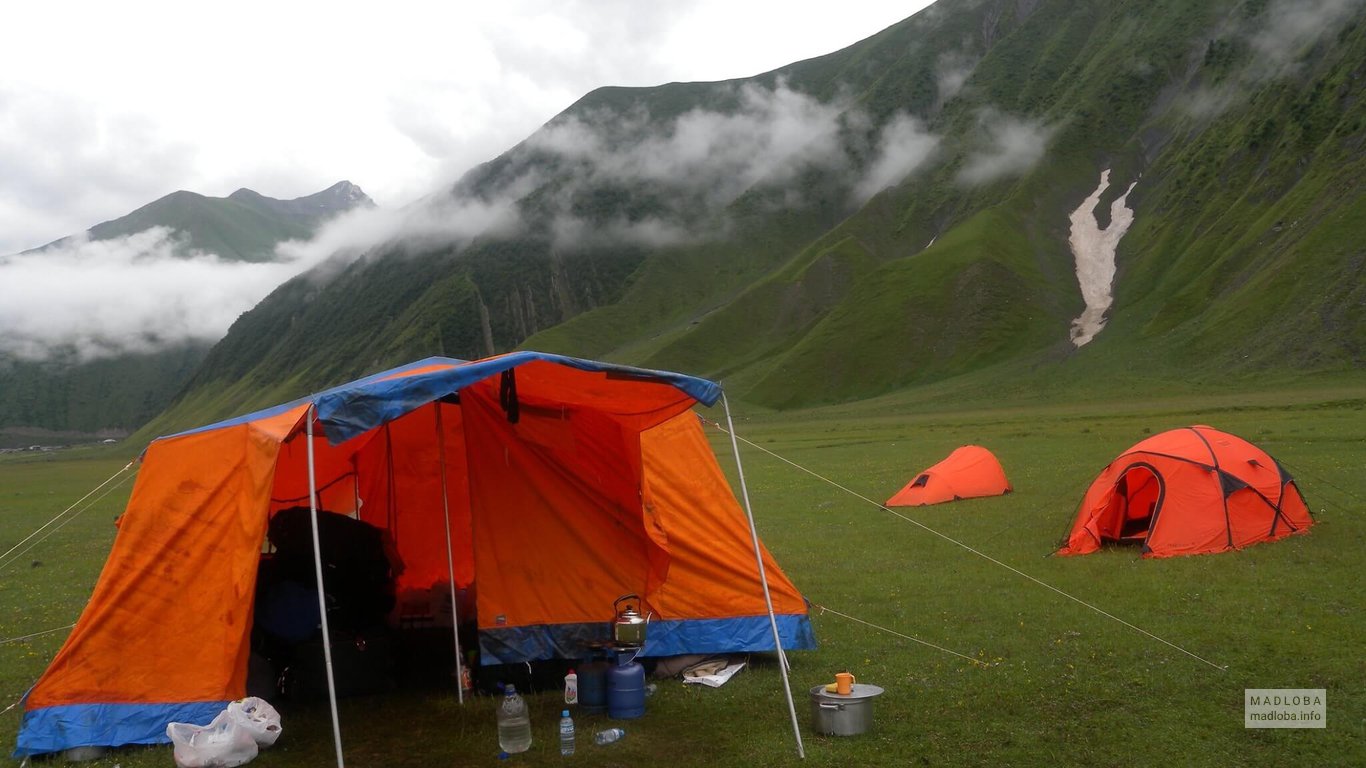 Остановка в горах с палатками с Рюкзак Тур