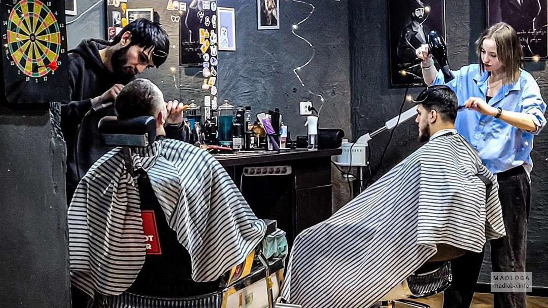 мастер делает стрижку в Clippers Barbershop