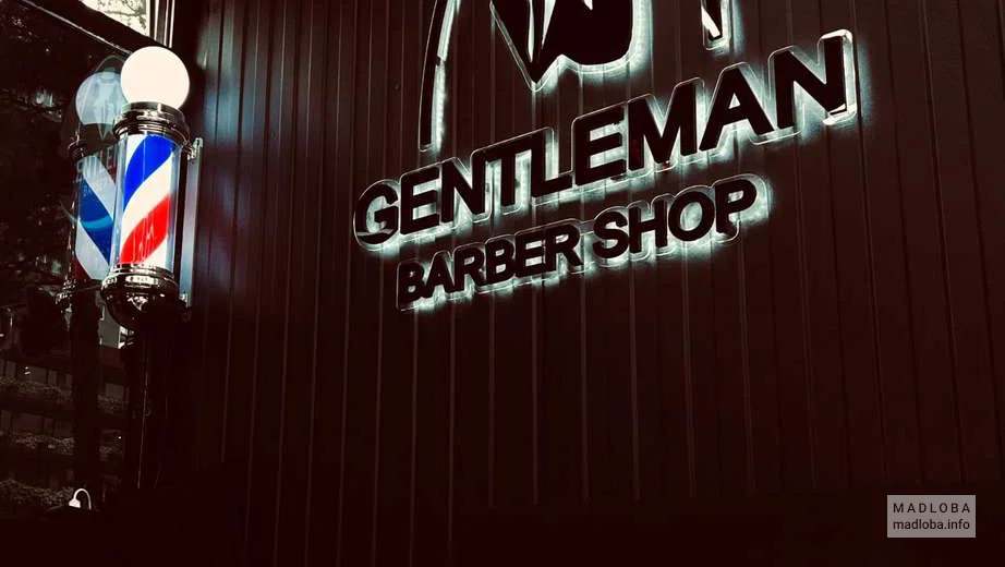 Барбершоп Gentleman стена с логотипом и шахматной доской на столе