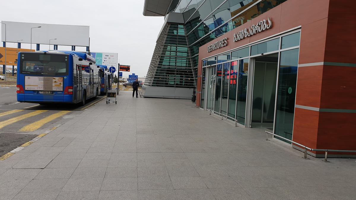 Синие пассажирские автобусы припаркованы у терминала международного аэропорта Тбилиси