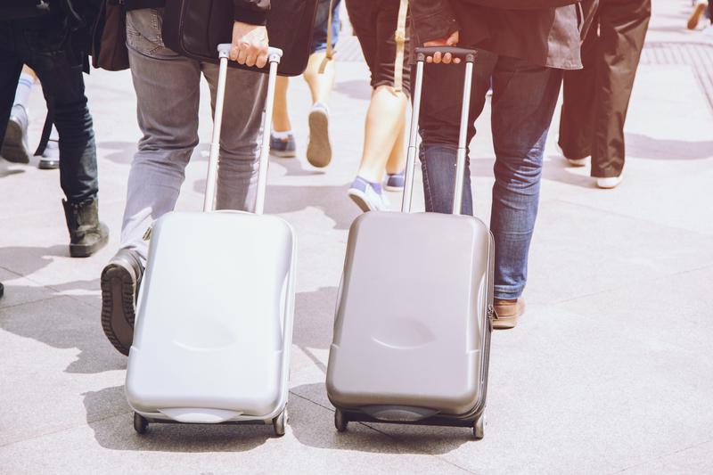 Мужчины с багажом идут в аэропорт.