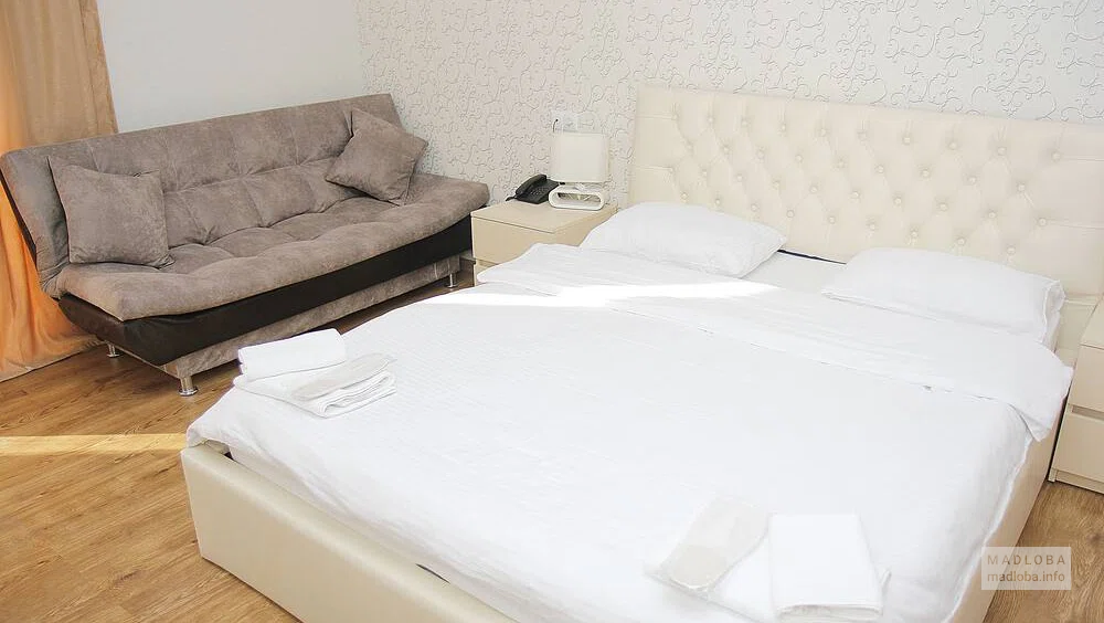 Кровать в номере отеля Дани