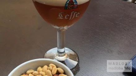 Пенный напиток и орешки в ресторане De Paris