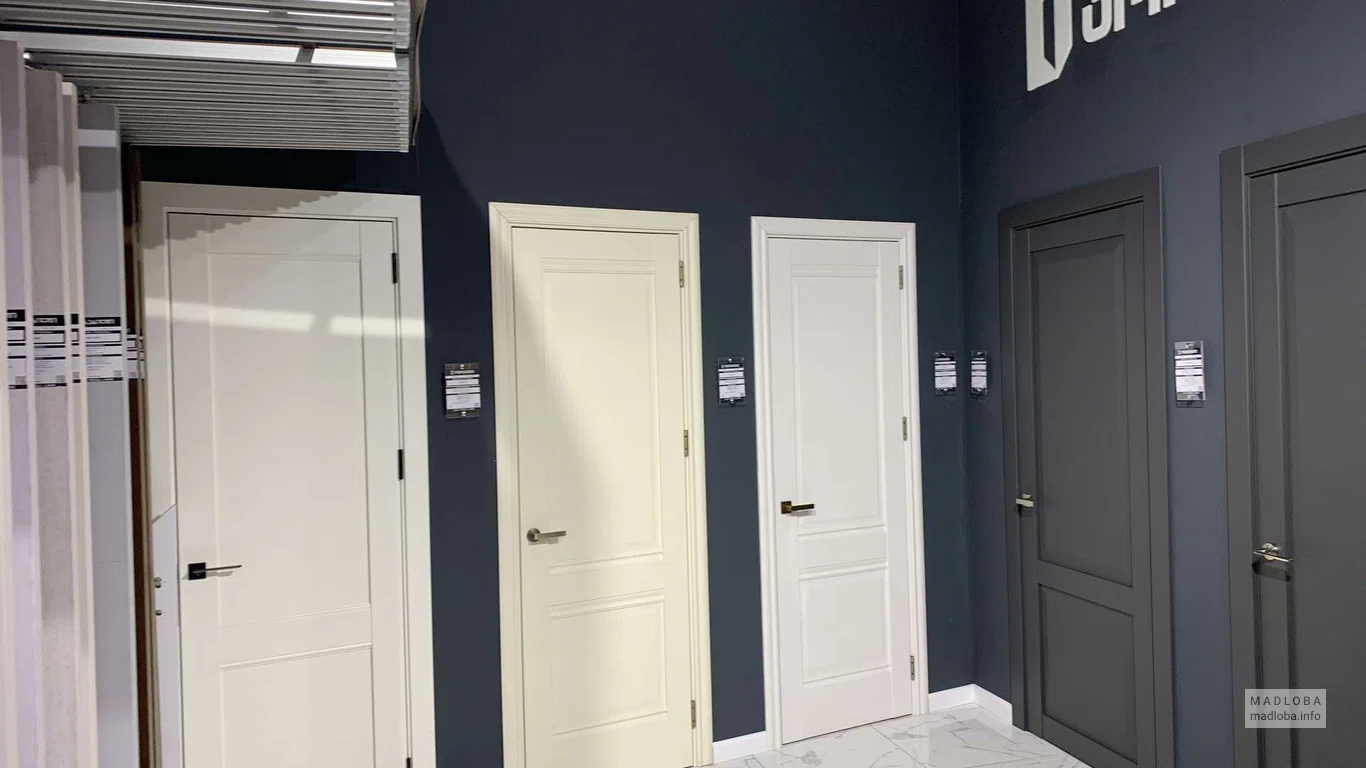 Белые двери с классическим дизайном и черной ручкой