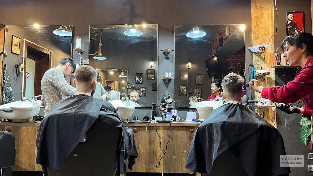 Барбершоп Gangster интерьер, барберы делают стрижку клиентам