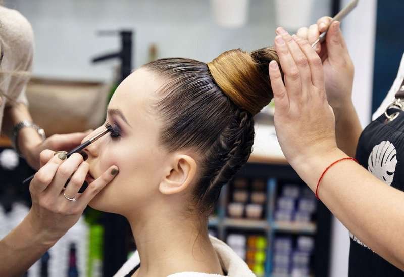 A makeup artist applies makeup in a beauty salon