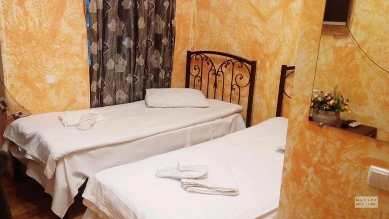 Кровать в номере гостевого дома Исани