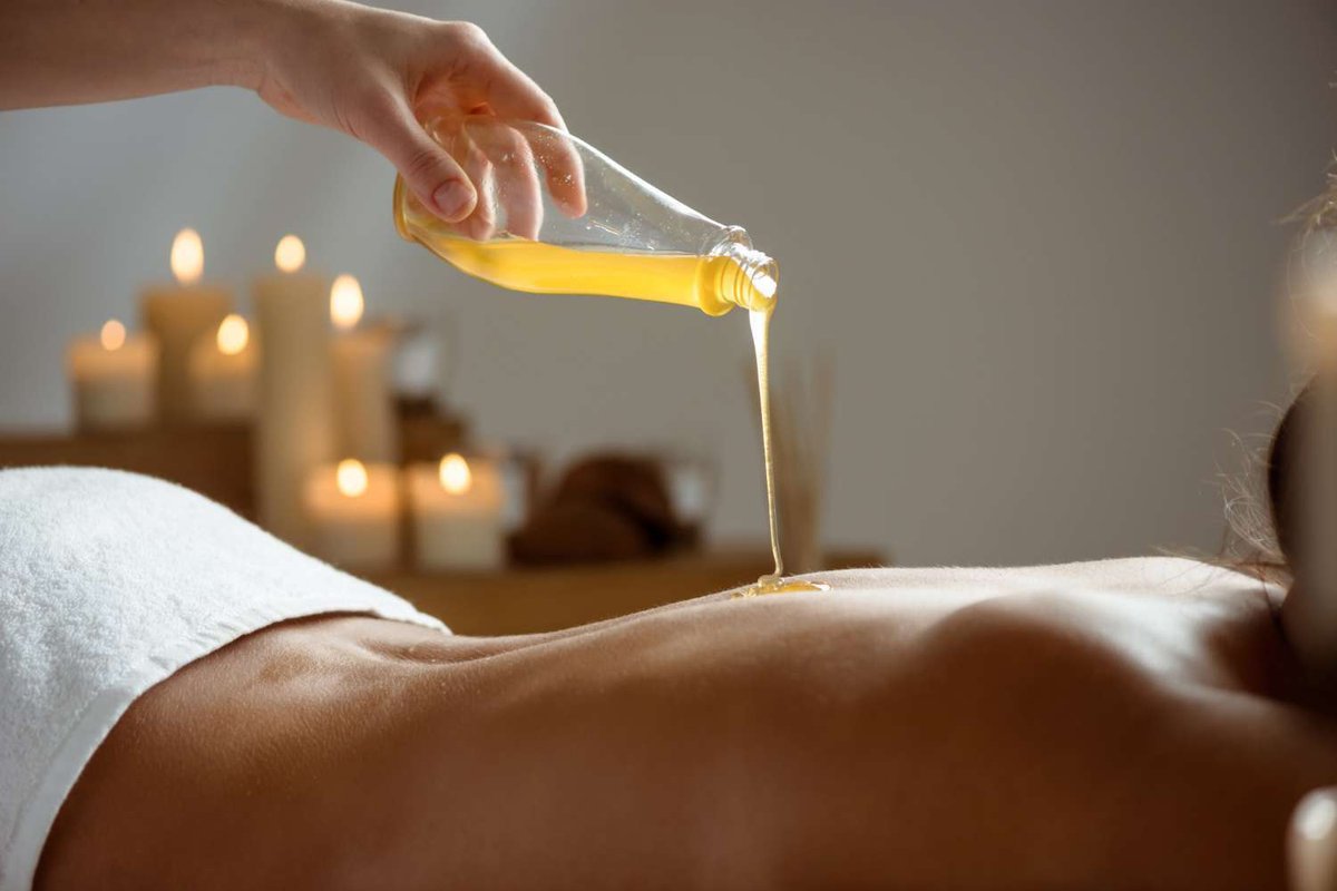 Honey flows down a woman's naked back in a massage parlor