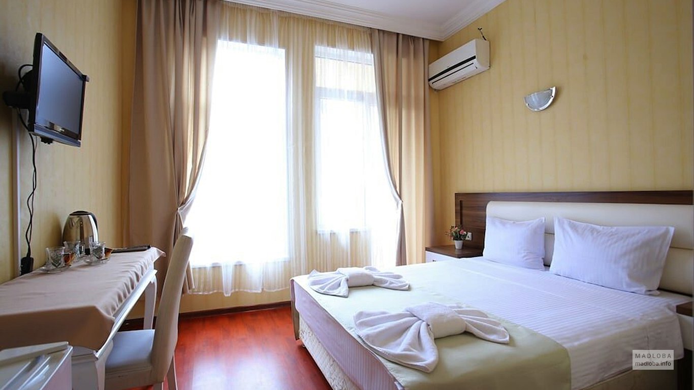 Кровать в номере гостиницы Аристократ