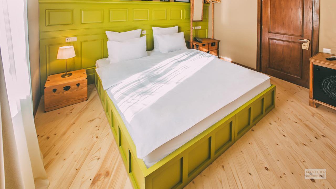 Двухспальная кровать в номере отеля “Киси”