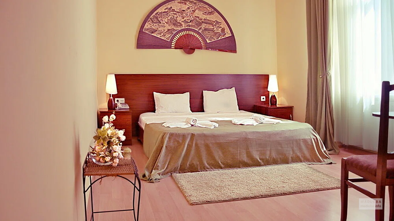 Кровать в номере отеля Tbilisi Garden