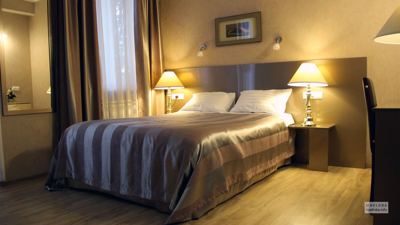 Кровать в номере Hotel Iliani в Тбилиси