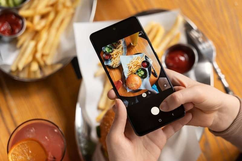Close-up of a person taking a photo of food
