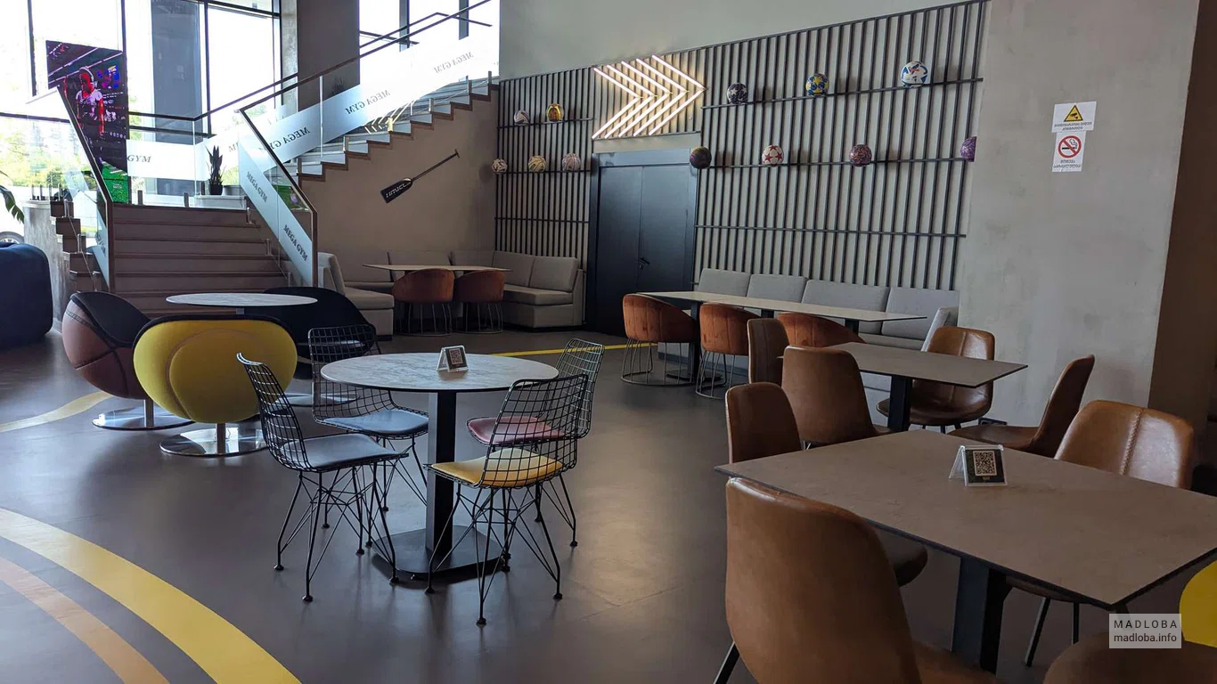 Столики в холе отеля, где находится Mega Gym Fitness