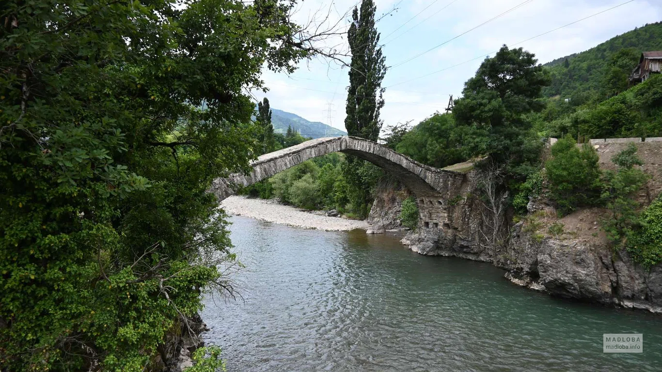 Спокойная река протекает под мостом Дандало
