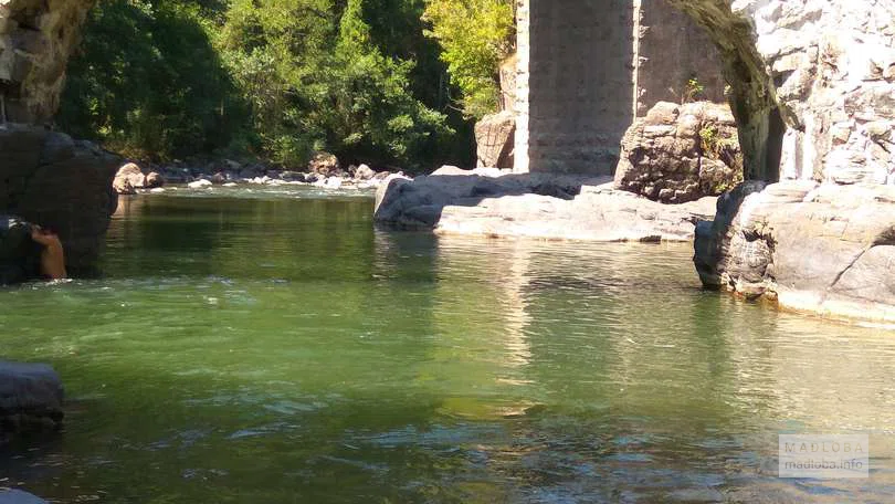 Изумрудного цвет арека протекает под мостом Фуртио