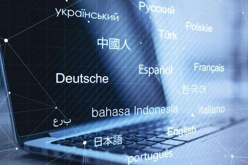A laptop keyboard overlaid with language names in Russian, English, Georgian-adjacent scripts, and others, connected by a network of lines — illustrating language choice for IT courses in Tbilisi, Georgia.