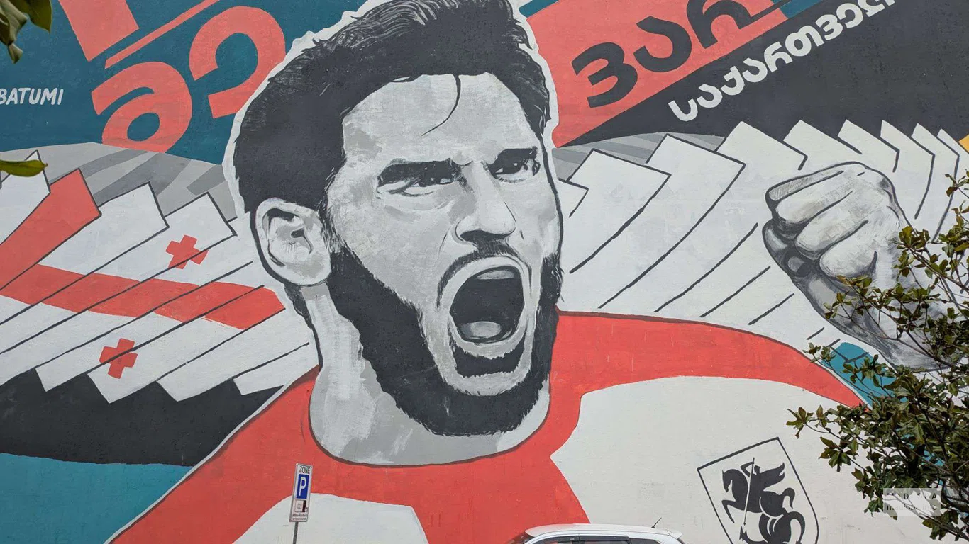 Мурал с изображением футболиста Хвичи Кварацхелия в центре города.