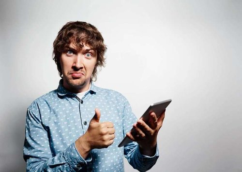 A man holds a tablet and gives a thumbs up, happy with the appliance repair service