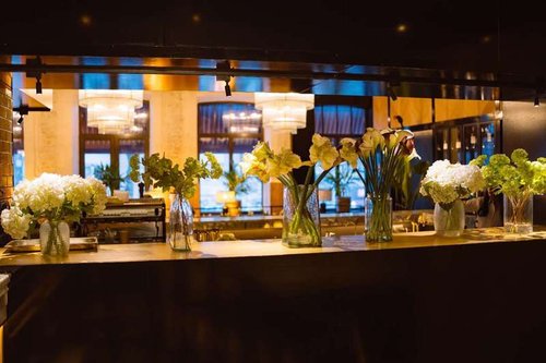 Vases filled with plants adorn the restaurant table, adding charm to the venue.