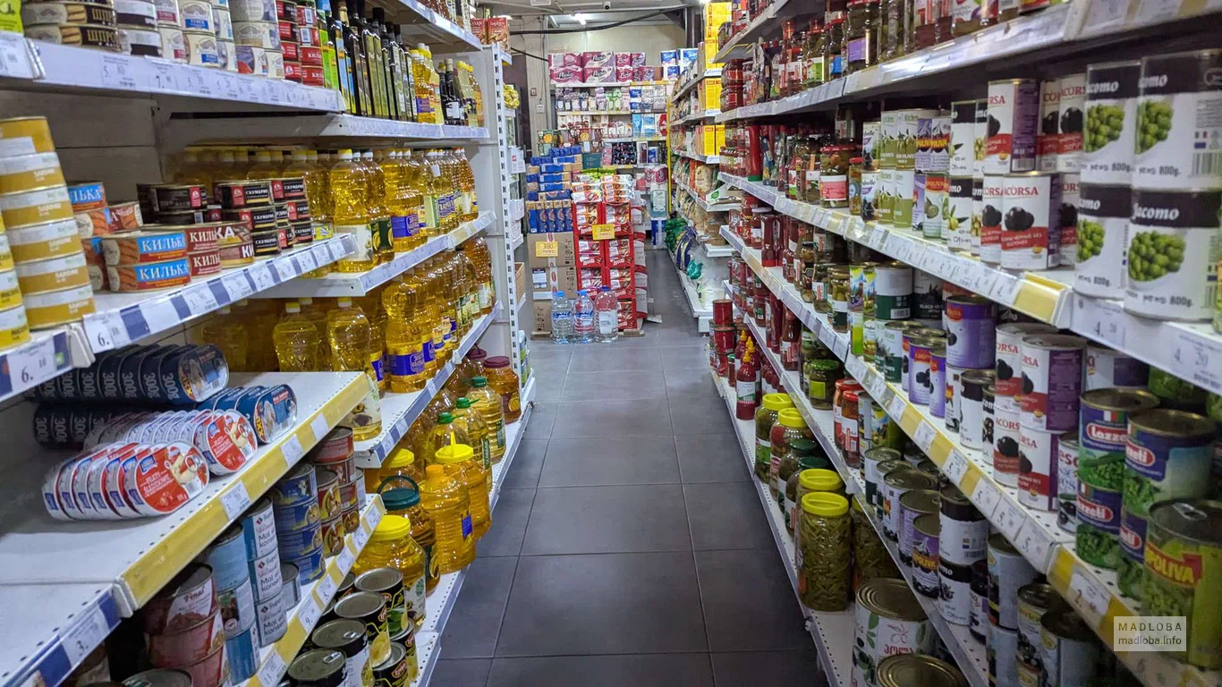 Консервы и масло на полках магазина Nazilbe