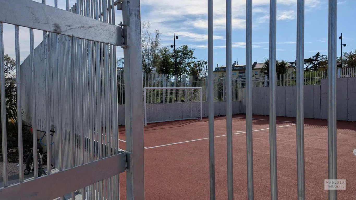 Закрытая площадка с красным покрытием подходит для игр на свежем воздухе — безопасно и удобно.