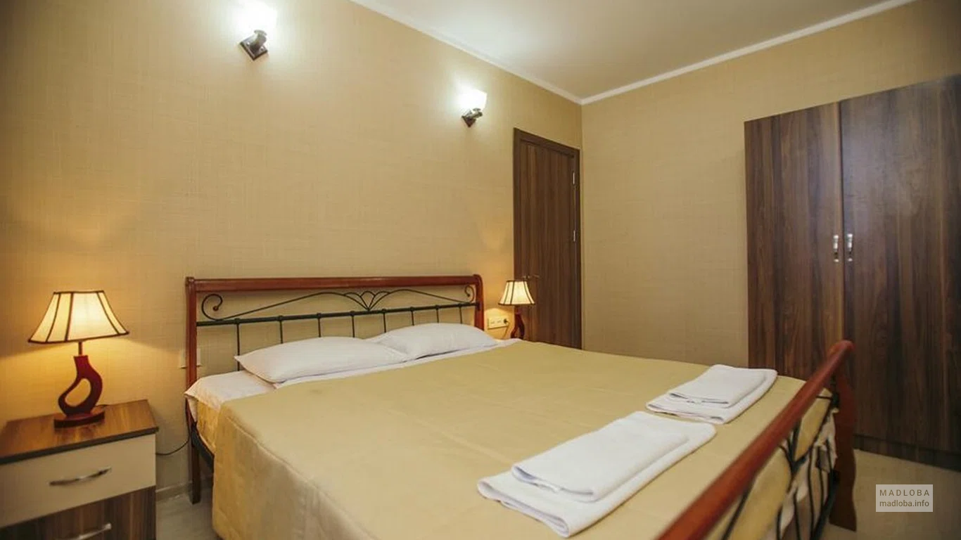 Кровать в номере отеля Ориент Люкс