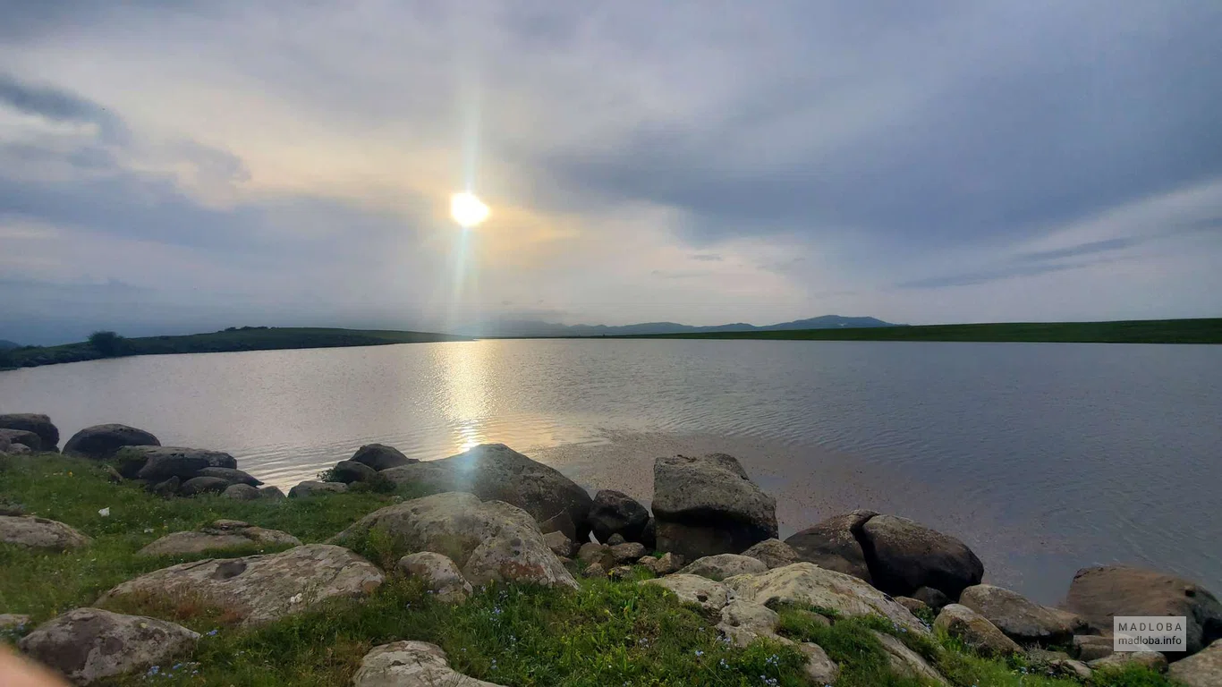 Солнце пробивается сквозь тучи для освещения озера Гохнари
