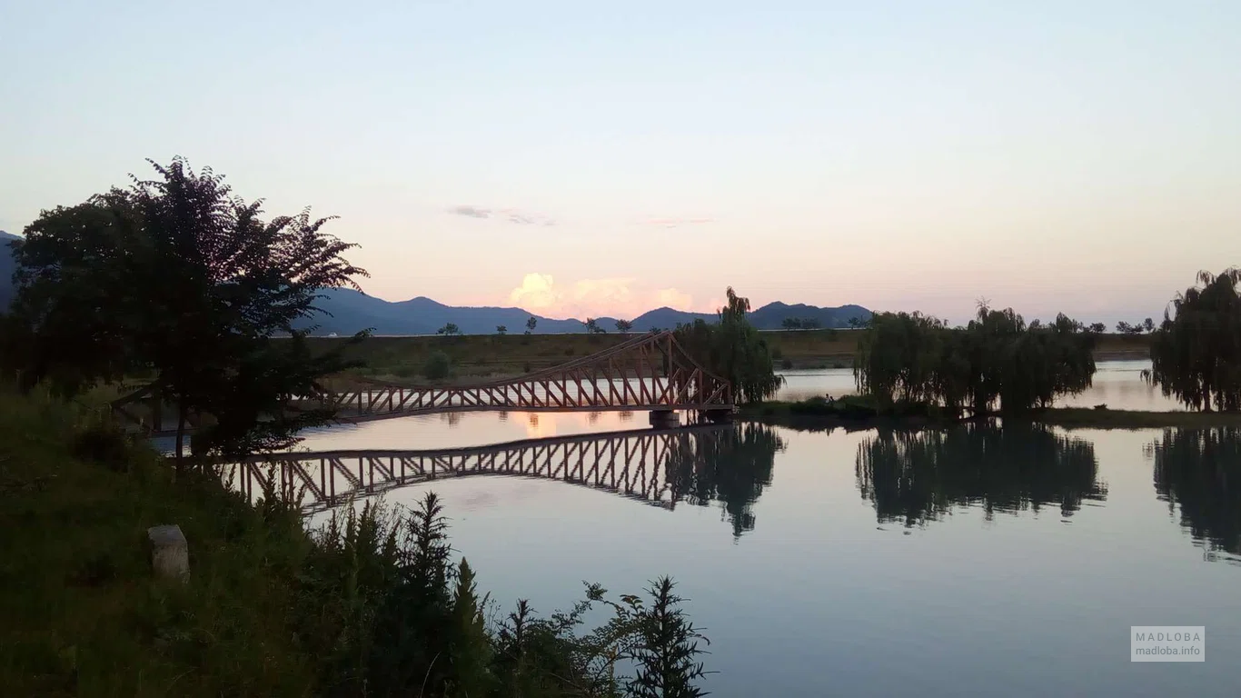 Вид сбоку на мостик к острову на Озере Ильи (Кварели) в вечерних сумерках