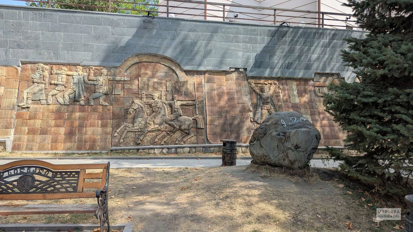 Каменная стена с барельефами и табличками