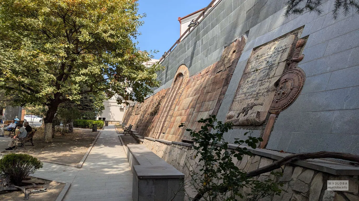 Каменная стена с барельефами и табличками