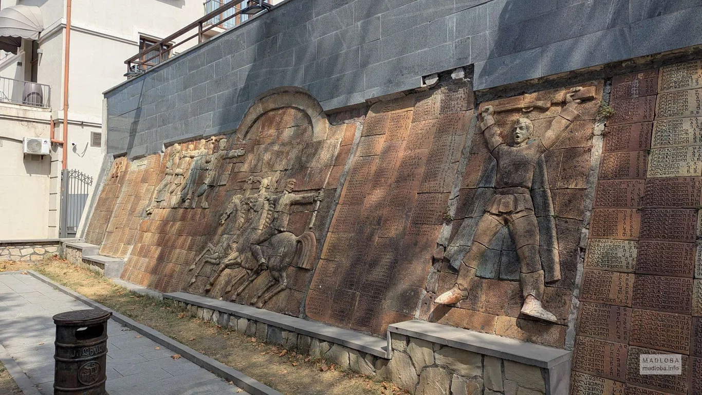 Каменная стена с барельефами и табличками