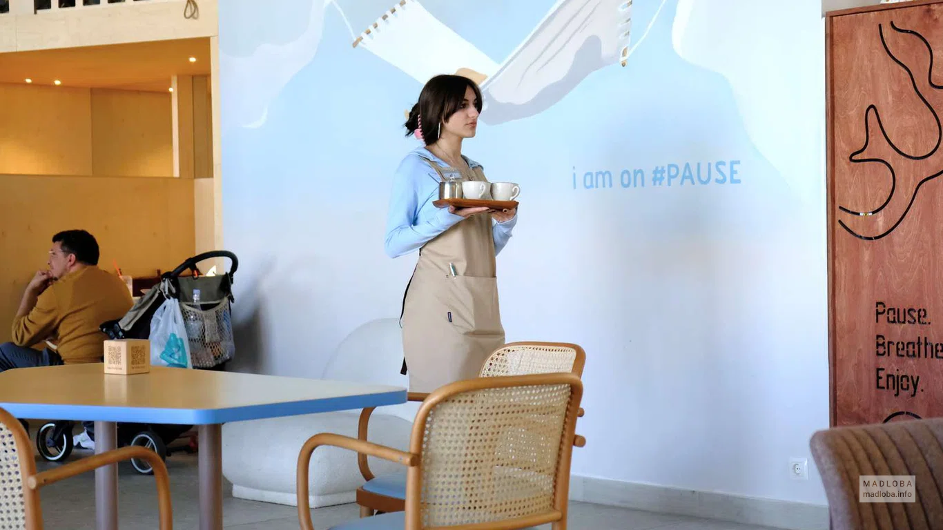 Официантка несет заказ посетителям