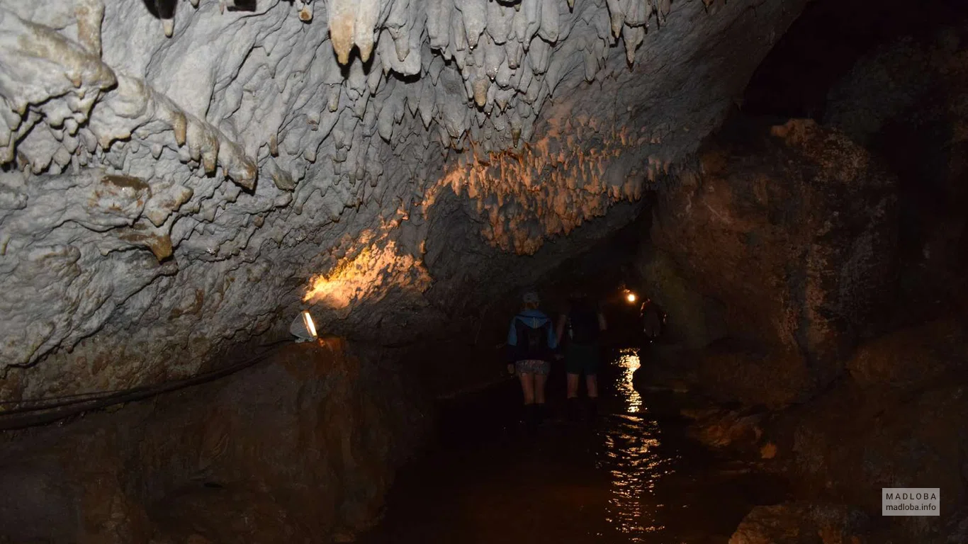 Туристы осматривают своды пещеры Абрскила двигаясь по реке