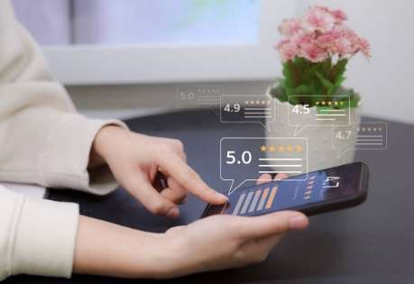 A user gives a 5-star rating and writes a review on the Google Maps mobile app on a smartphone.