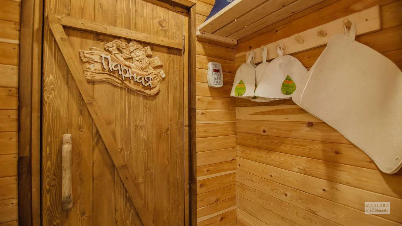 Sauna Orbi City вход в парилку, банные шапки на вешалке