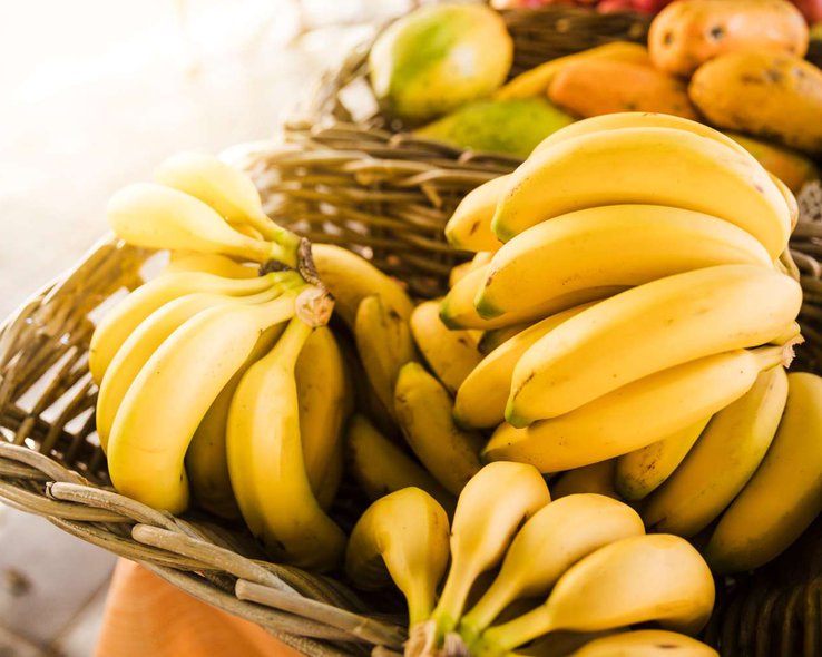 Спелые желтые бананы в плетеной корзине в магазине фруктового рынка.jpg