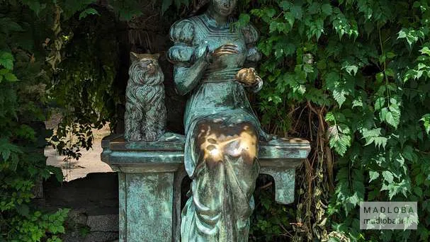 Старая стена и скульптура "Девушка с котом"