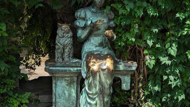 Старая стена и скульптура "Девушка с котом"