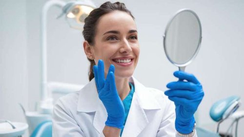 A girl admires her teeth at the dentist's office