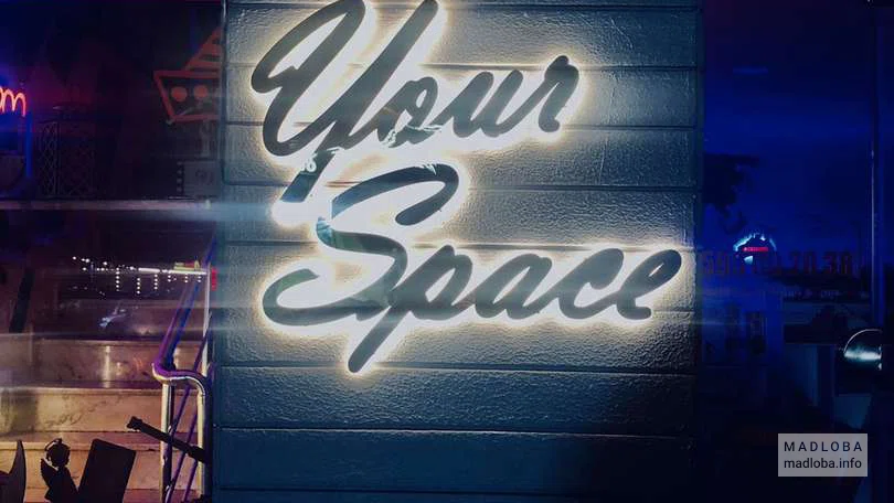 Подсвеченная вывеска на входе в Your Space