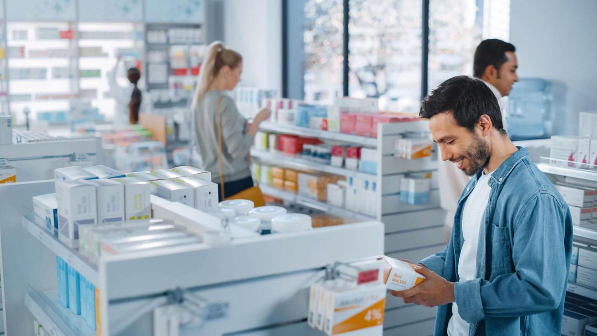 Мужчина покупает лекарство в аптеке